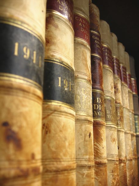 Libros antiguos con lomos de cuero, numerados y organizados por año.
